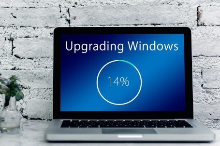 Windows 11 Installation und System-Optimierung Laptop mit Fortschrittsanzeige: Windows-Upgrade bei 14%.